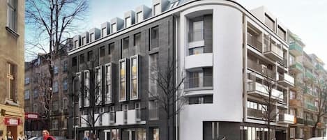 Un edificio moderno con varios balcones, amplias ventanas y una fachada curva.