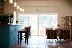 Un espace bar avec des tabourets, un comptoir et des lampes suspendues.