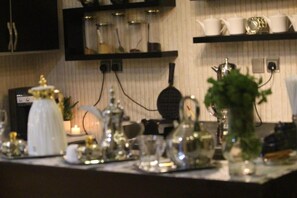 A kitchen counter with various kitchenware and appliances. - Aros Alfaisaliah Furnished Units (Dammam)