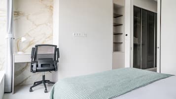 Quarto com cama, escrivaninha e cadeira.