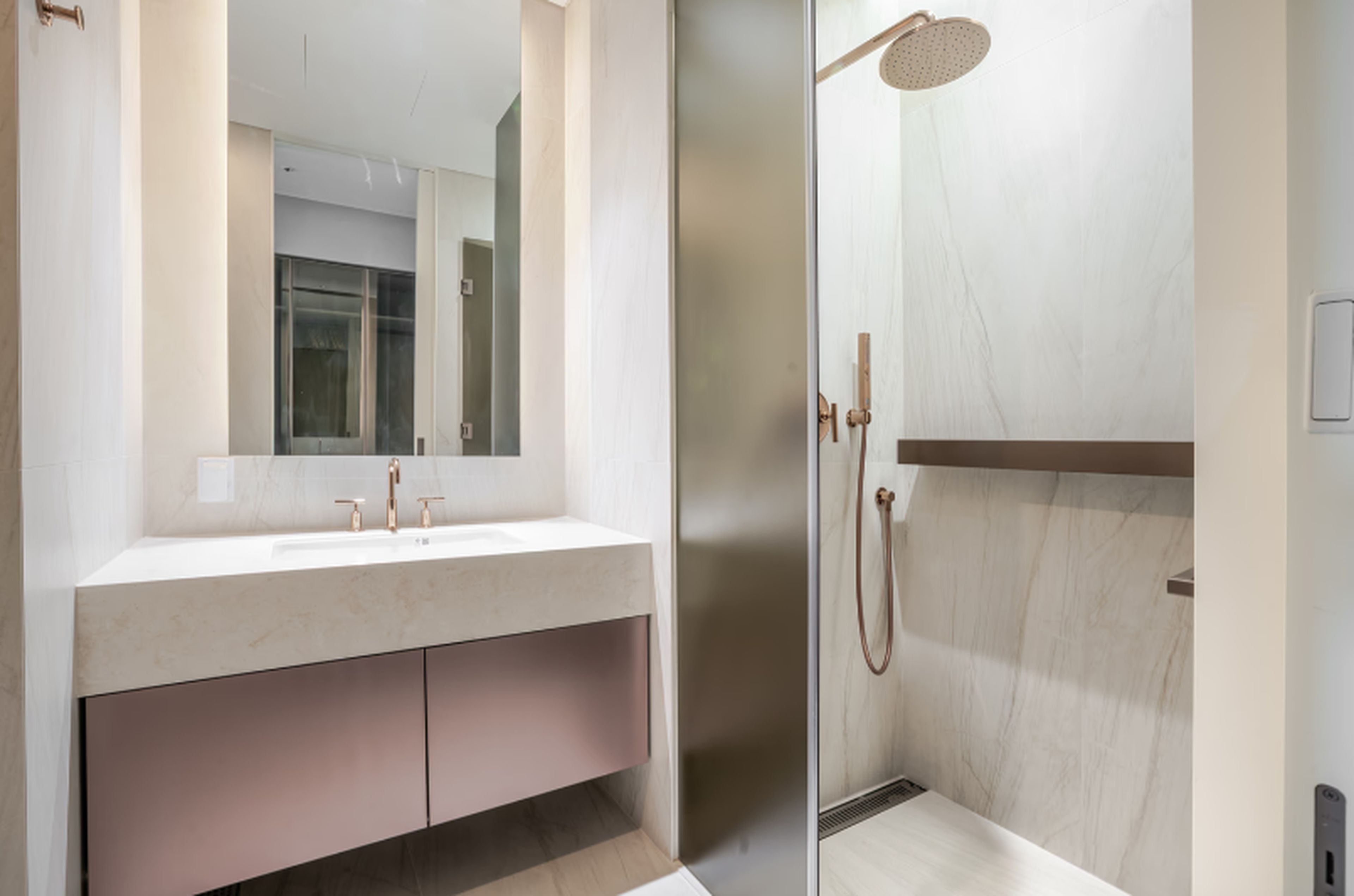 Un baño moderno con un espejo grande, un lavabo y una ducha.