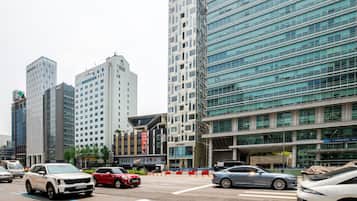 A city street with modern buildings, a crosswalk, and cars.