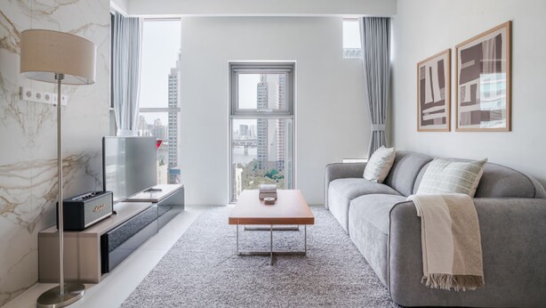 A modern living room with a grey sofa, a coffee table, a TV, and a city view through large windows. - Orchid Cheongdam - Executive Suite - 5 mins to Coex by Taxi (Seoul)