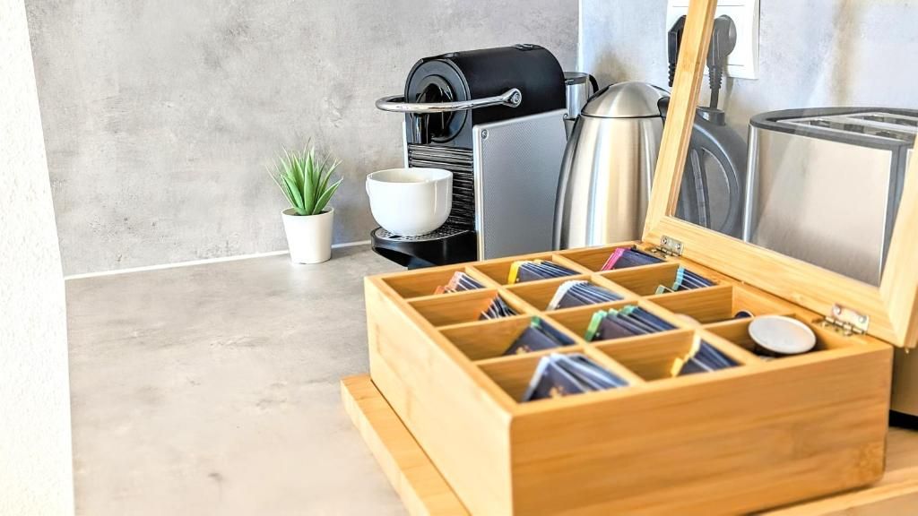 A kitchen with a coffee machine, a toaster, and a wooden box with compartments.