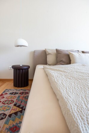 A bedroom with a bed, a bedside table, a lamp, and a patterned rug. - 100 m² · up to 6 guests · 3 bedrooms · 8 km from Bamberg (Kemmern)