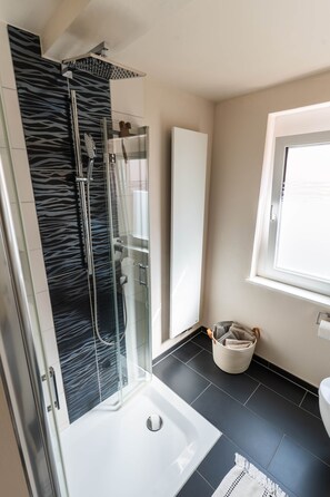 A modern bathroom with a glass-enclosed shower, a white sink, and a window. - 100 m² · up to 6 guests · 3 bedrooms · 8 km from Bamberg (Kemmern)