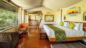 A spacious tented room with a large bed, a chair, and a view of the outdoors. - Azure Mara Haven (Maasai Mara)