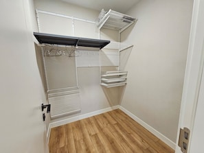 A storage closet with shelves, a hanging rack, and a metal shelf unit. - Stylish 2BR Apartment at Gerlug Vista with Skyline Views (Ulaanbaatar)