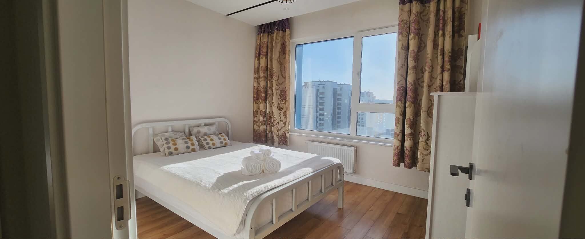 Un dormitorio con cama, ventana y radiador.