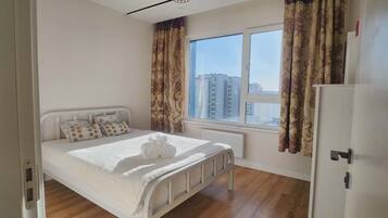 Un dormitorio con cama, ventana y radiador.