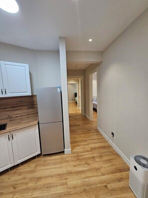 A modern kitchen with white cabinets, a refrigerator, and a wooden countertop. - Stylish 2BR Apartment at Gerlug Vista with Skyline Views (Ulaanbaatar)