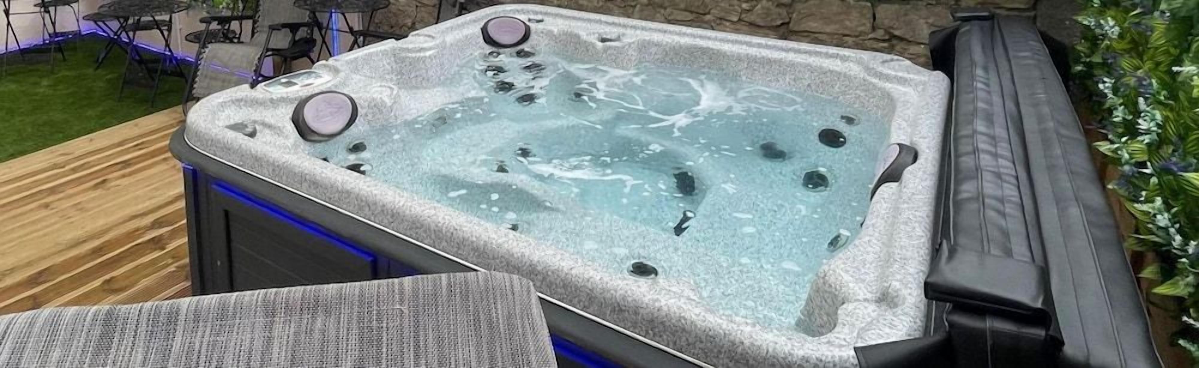A hot tub with jets, surrounded by outdoor furniture and plants.