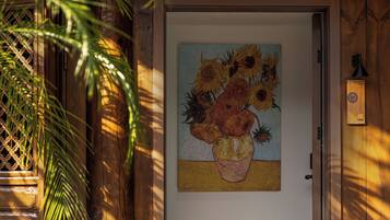 Una puerta con un bodegón de girasoles en un jarrón.