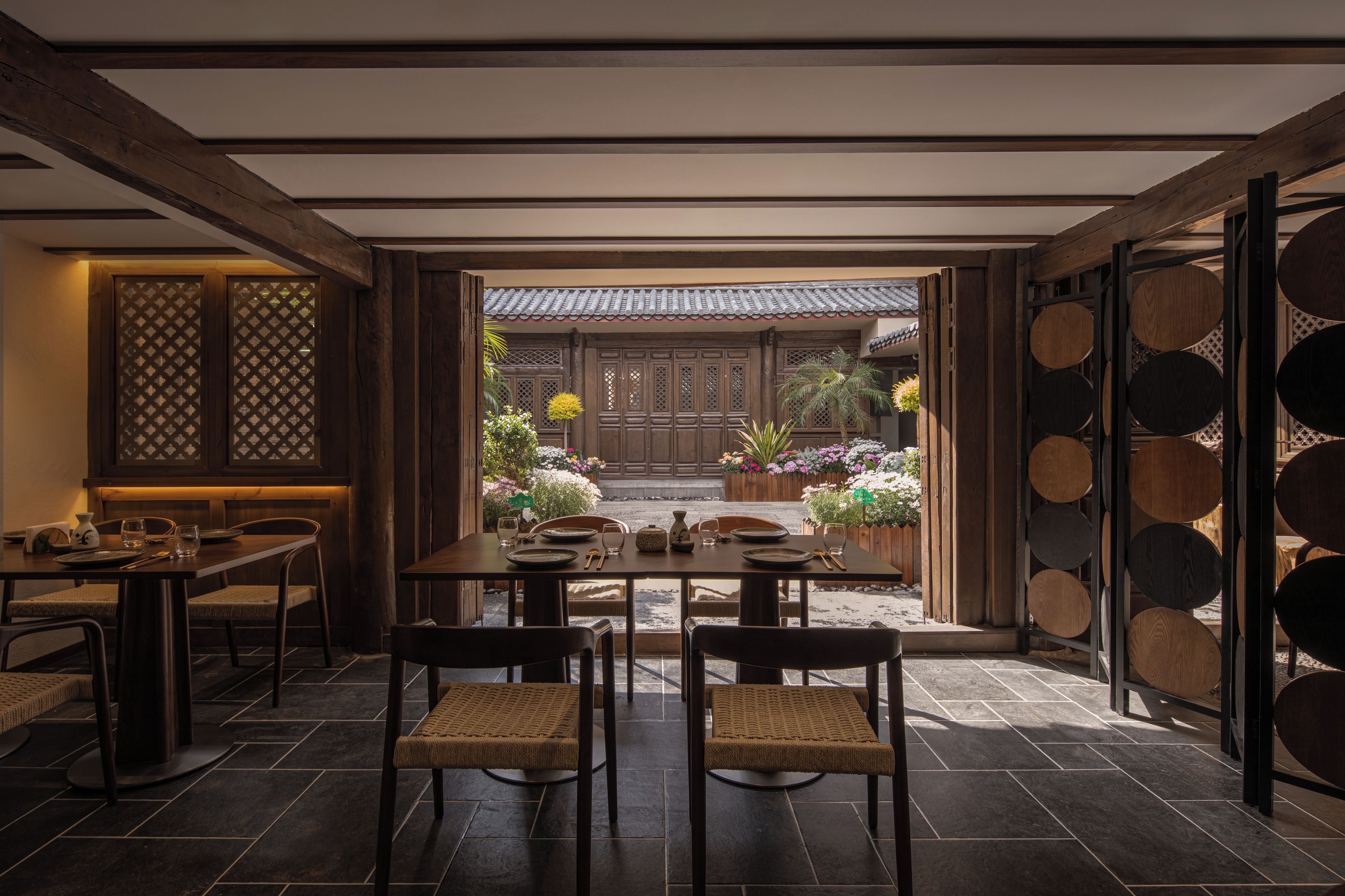 Een traditioneel Japans eetgedeelte met tatami vloermatten, een lage tafel en houten stoelen.