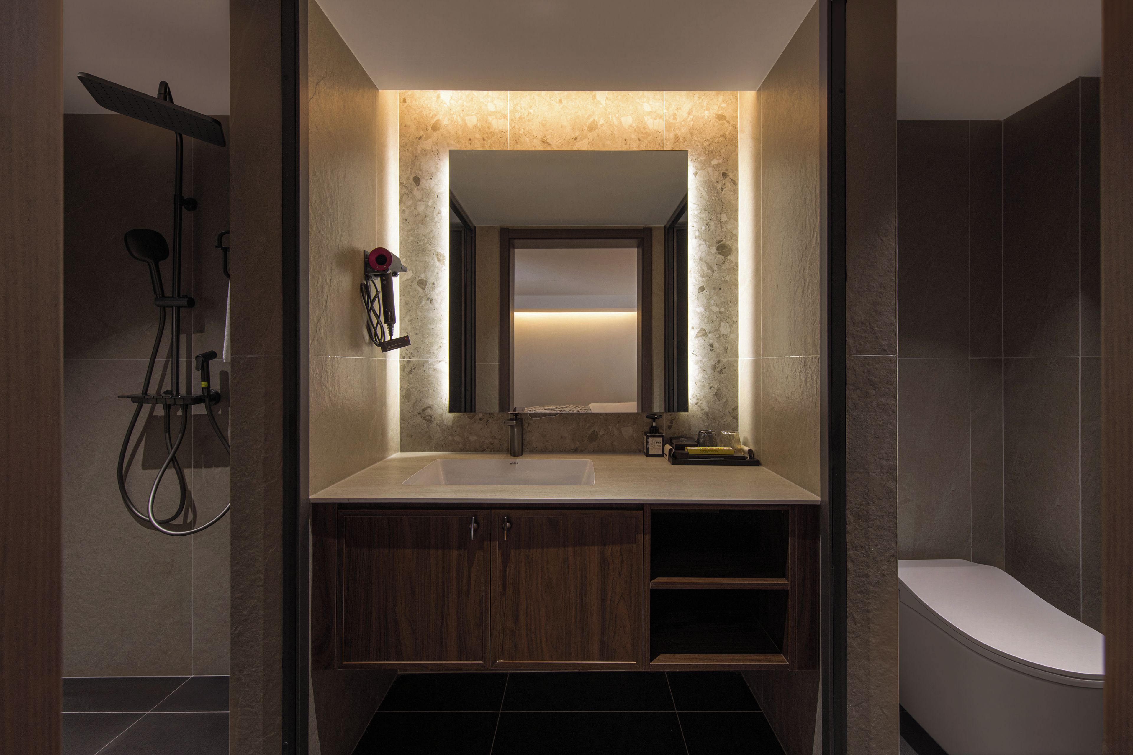 Ein modernes Badezimmer mit einem großen Spiegel, einem Waschbecken und einer Toilette.