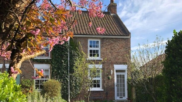 A two-story brick house with a visible front garden and a white fence. - Ceilidh Cottage (York)