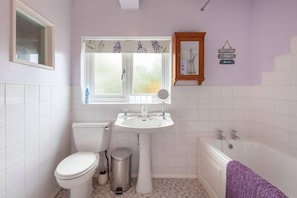 A bathroom with a toilet, sink, and bathtub.