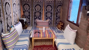A cozy room with a bed, a small table, and a window. - Casa Meryem (Chefchaouen)