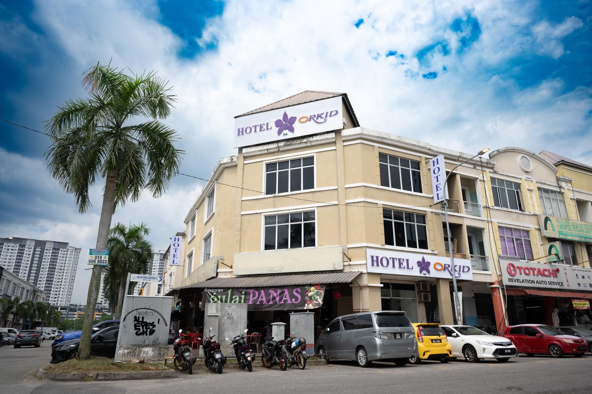 A hotel with a sign for 'HOTEL ORKID' and a restaurant named 'Sulai PANAS' on the ground floor.