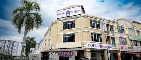 A hotel with a sign for 'HOTEL ORKID' and a restaurant named 'Sulai PANAS' on the ground floor.