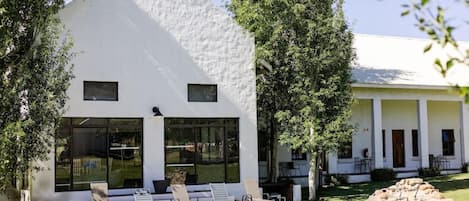 A modern white building with a pool and lounge chairs.