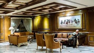 A lobby with a patterned floor, a sofa set, and a painting on the wall.