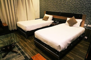 Ein Hotelzimmer mit zwei Betten, einem Glastisch und einer Wand mit Muster.