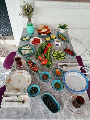 Una mesa dispuesta con diversos platos, incluyendo pan, verduras y salsas, sobre una superficie de mármol.