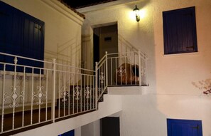 Una escalera con barandillas blancas y puertas azules.