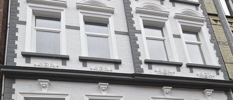 A multi-story building with white exterior walls and multiple windows.