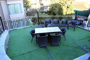 An outdoor patio with a table and chairs, surrounded by a decorative fence. - Silver Arch Hotel (Dehradun)