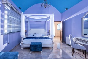 Un dormitorio con cama con dosel, tocador con espejo y candelabro.