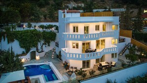 Ein mehrstöckiges Gebäude mit Pool, Sitzgelegenheiten im Freien und einem Balkon.