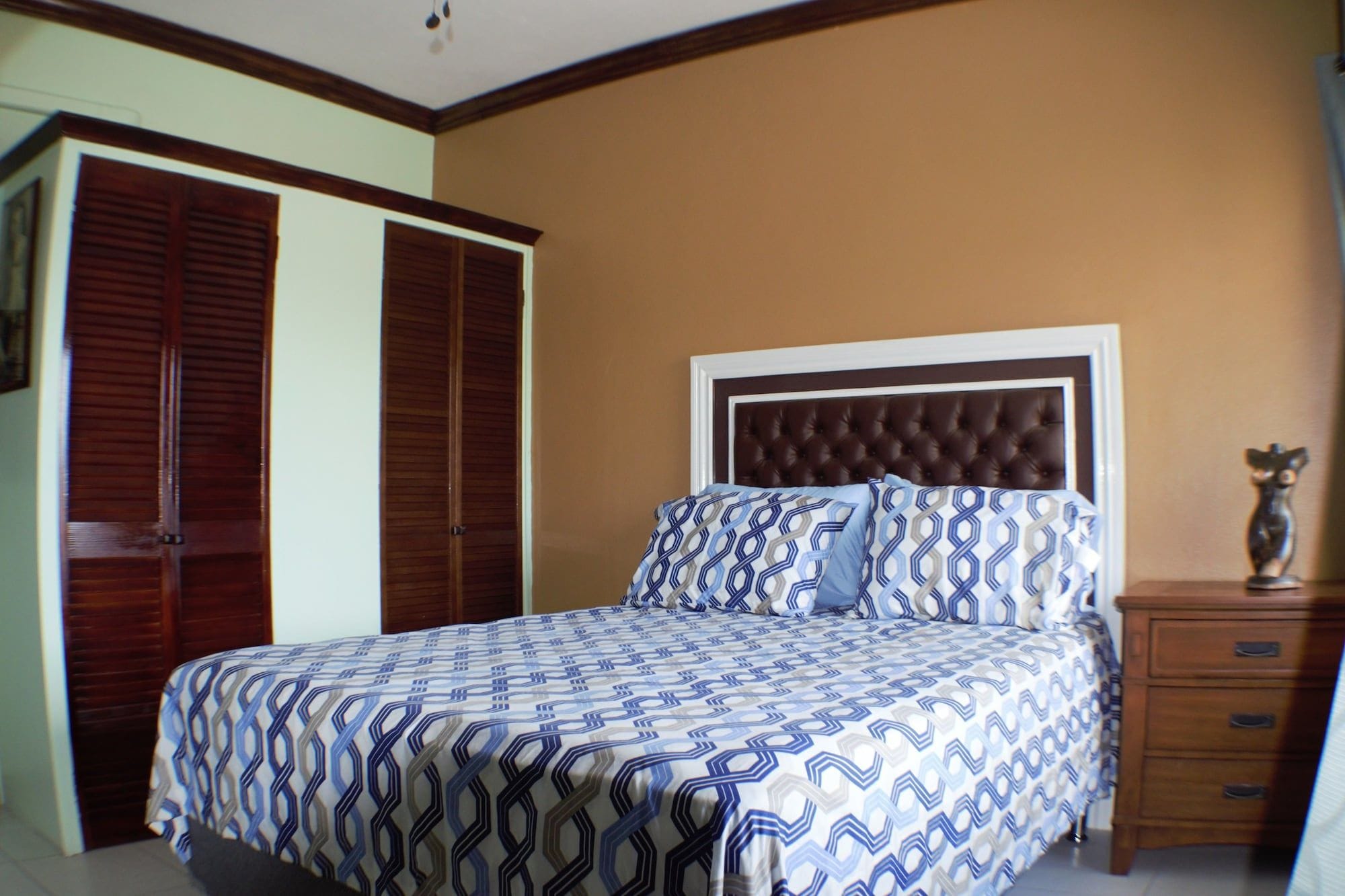 Une chambre à coucher comprenant un lit, une table de chevet, une commode et une armoire.