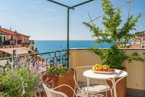 A balcony with a table set with fruit, overlooking a coastal view. - The First Riomaggiore 5 Terre (Riomaggiore)