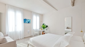 A modern hotel room with a large bed, a desk, a chair, and a large mirror. - The First Riomaggiore 5 Terre (Riomaggiore)