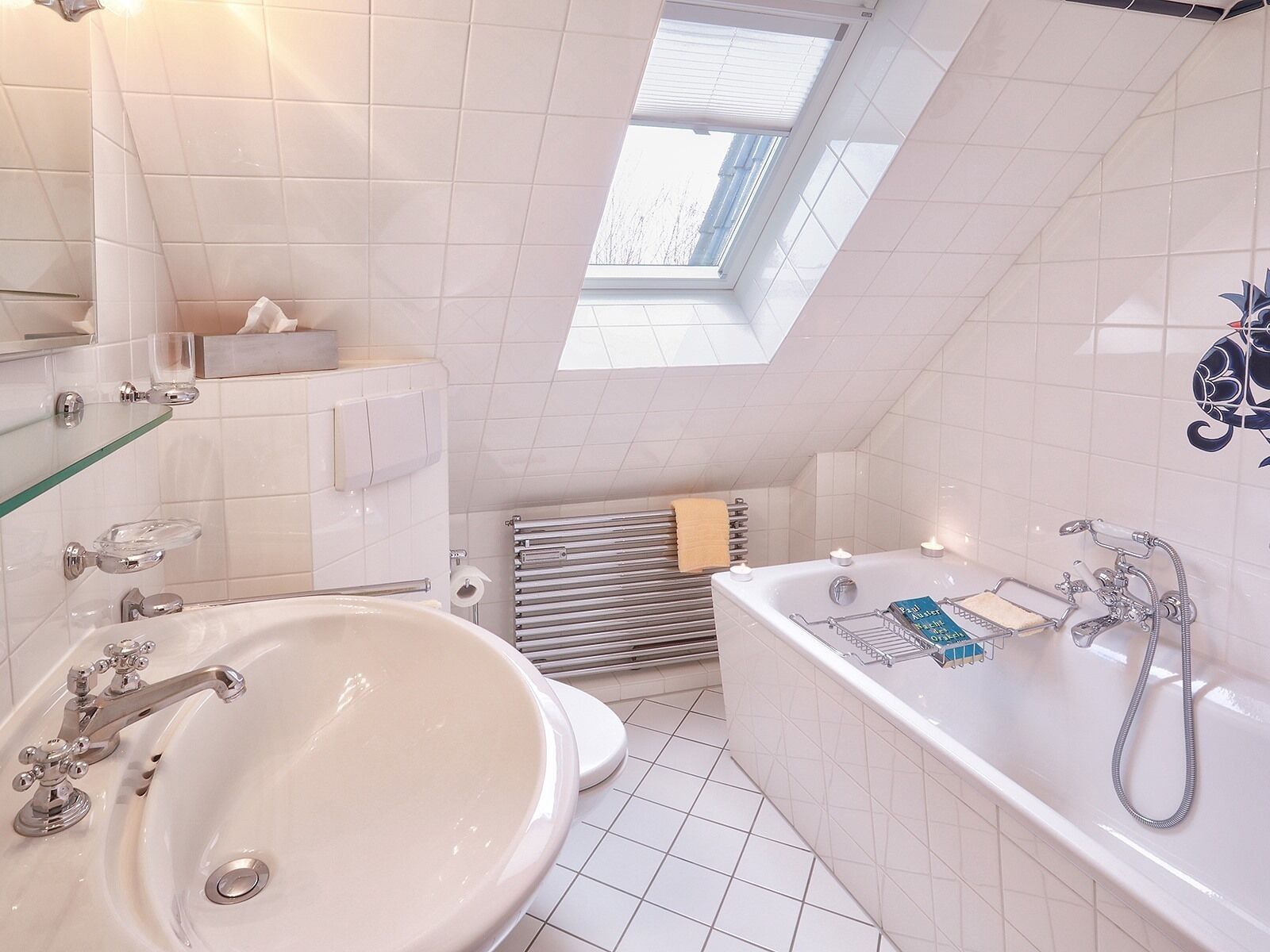 Un bagno moderno con una vasca freestanding, un lavandino ampio e un lucernario.