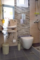 Un baño moderno con lavabo, inodoro y ducha.