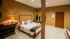Una habitació d'hotel amb un llit, una tauleta de nit, una làmpada i una porta.