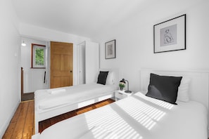 Ein modernes Schlafzimmer mit Bett, Nachttisch und einer Tür zu einem anderen Raum.
