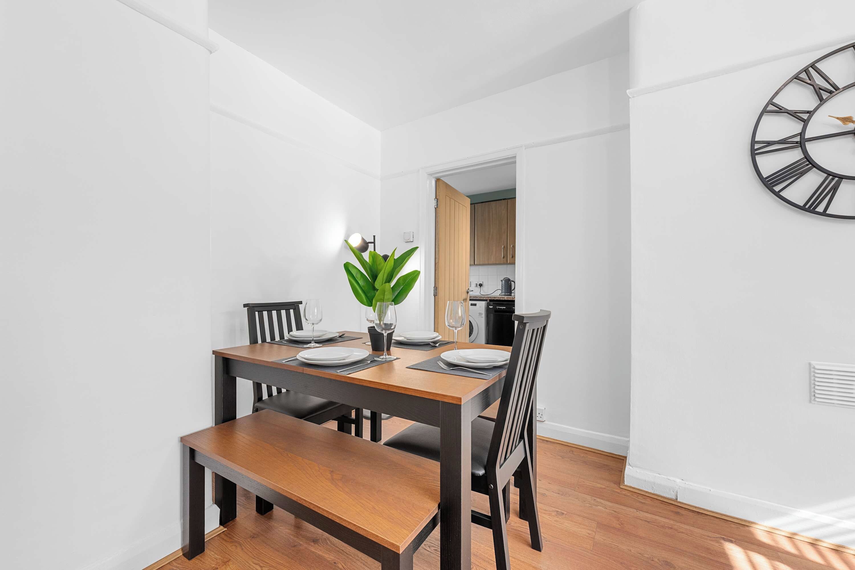 Un coin repas avec une table en bois, des chaises et une plante en pot.