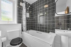 Ein Badezimmer mit Badewanne, Toilette, Waschbecken und Dusche.