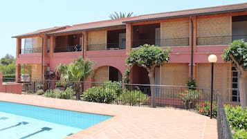 Ein mehrstöckiges Hotel mit Schwimmbad, Außenbereich und Garten.