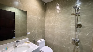 A bathroom with a sink, toilet, and shower. - Triple Tree Hotel (Al-Hofuf)