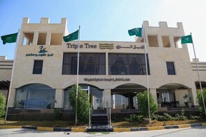 A building with a sign reading 'Triple Tree' and Arabic text.