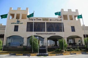 A building with a sign reading 'Triple Tree' and Arabic text.