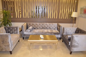 A living room with a tufted sofa, two armchairs, and a coffee table.