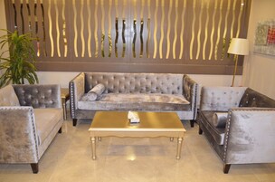 A living room with a tufted sofa, two armchairs, and a coffee table.