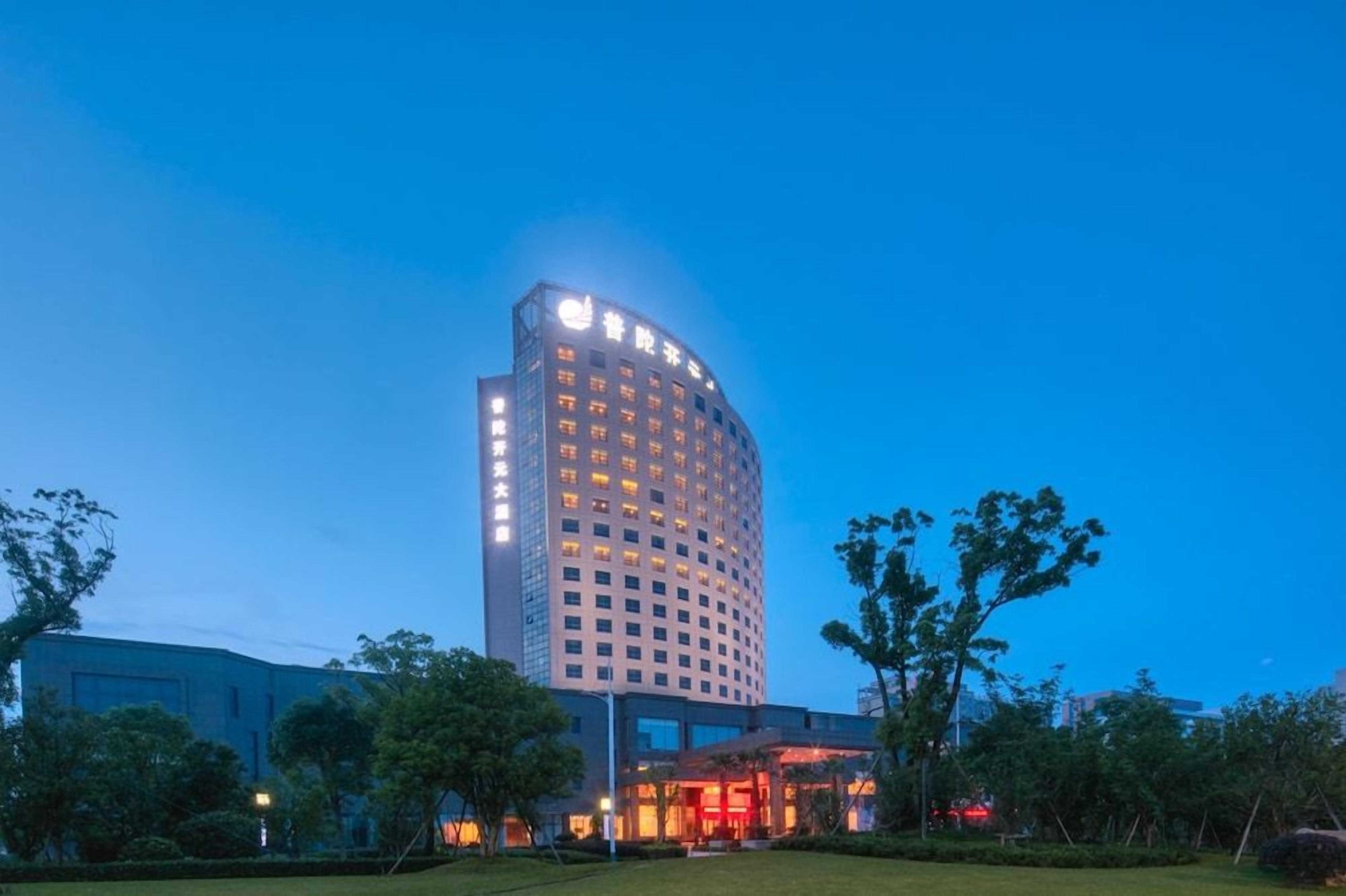 Un hotel de varios pisos con una entrada destacada y señalización iluminada.