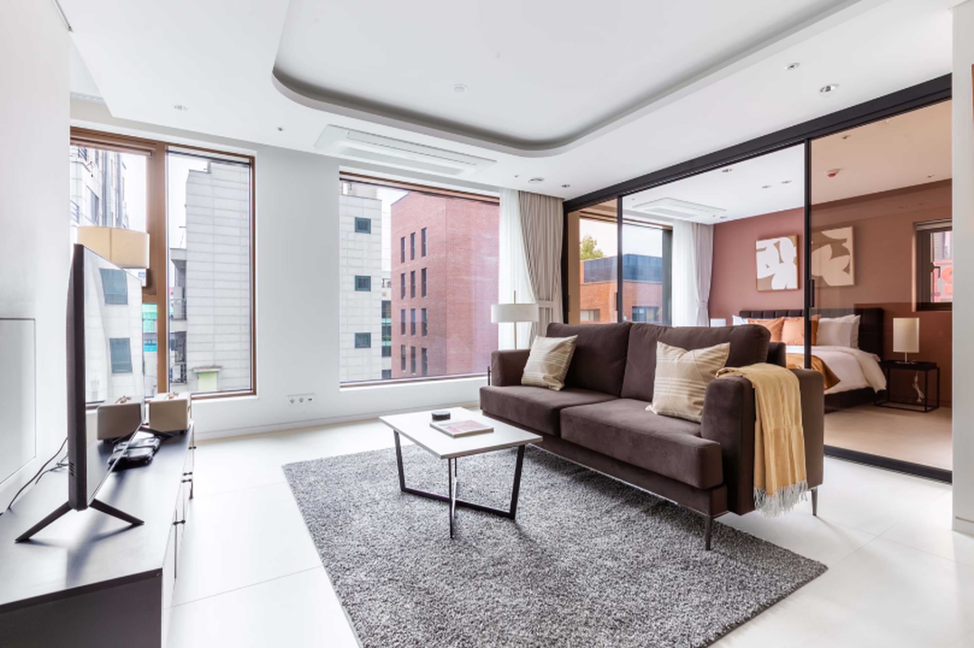 A modern living room with a sofa, coffee table, and a large window.